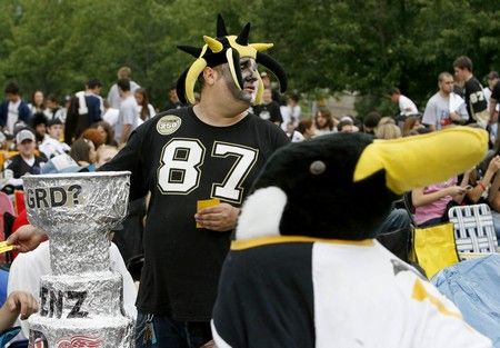 Další z příznivců Penguins je zase vybaven replikou Stanley Cupu. | Foto: Reuters