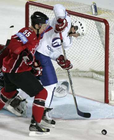 Kanaďan Nick Schultz (v červeném) atakuje Erika Spetse z Norska. | Foto: Reuters