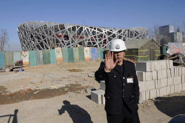 Čínský policista střeží olympijské staveniště. | Foto: Reuters