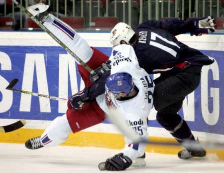 Ryan Kesler z USA (v tmavém) poslal k zemi českého obránce Jana Hejdu. | Foto: Reuters