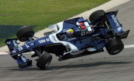 Williams Australana Marka Webbera vylétl při kolizi krátce po startu GP USA pěkný kus nad povrch okruhu v Indianapolis. | Foto: Reuters