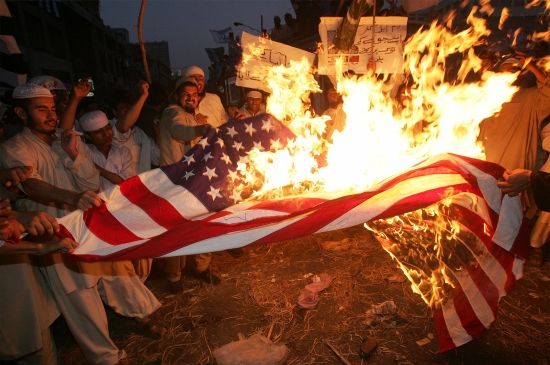 Stoupenci opoziční Islámské aliance pálí vlajku USA v pákistánském Karáčí. Desetitisíce lidí se tam sešly na protest proti karikaturám, ale zaměřili se také na kritiku vlády a USA | Foto: Reuters