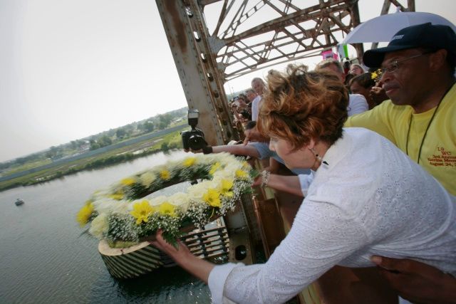 Žena háže věnec jako přípomínku obětí hurikánu Katrina, který New Orleans zasáhl přesně před třemi lety | Foto: Reuters