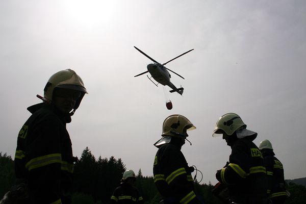 Z provizorního letiště v Harrachově vyrážel policejní vrtulník vybaven bambivalem do akce celkem pět krát. Vak na vodu plnili hasiči z přistavených cisteren. | Foto: Martina Machová