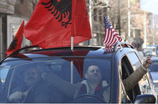 Řidič v Mitrovici oslavuje s kosovskou a americkou vlajkou. | Foto: Reuters