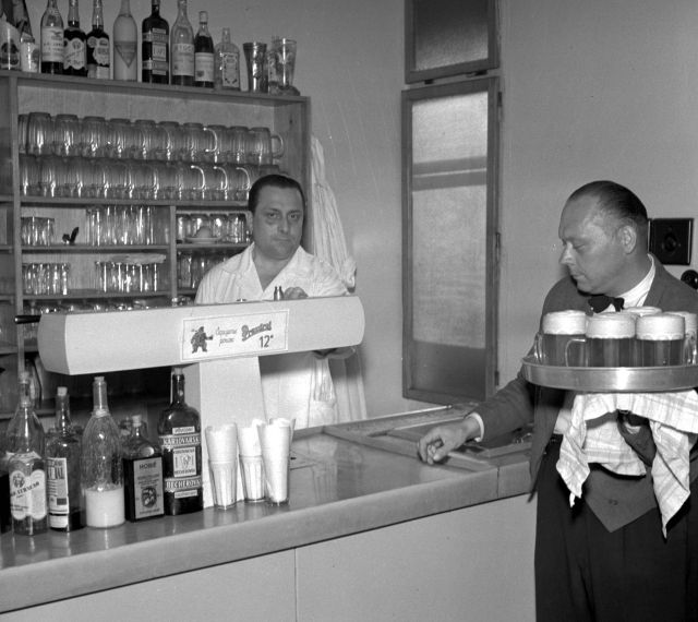 Klasická restaurace U Kalicha, rok 1957. Pan výčepní si poněkud nedůvěřivě měří fotografa. | Foto: ČTK