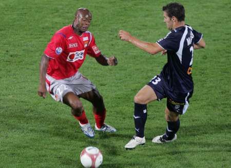 Lyonský Sylvain Wiltord bojuje o míč s Florianem Marangem z Girondins Bordeaux na stadionu v Bordeaux. | Foto: Reuters