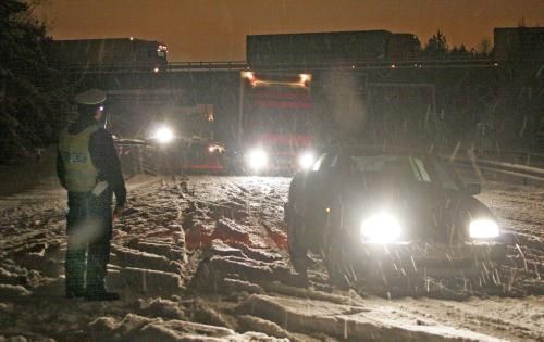 Policista odklání dopravu z dálnice, která musela být v noci ze soboty na neděli 18. prosince uzavřena kvůli hustému sněžení a dopravním nehodám. | Foto: ČTK