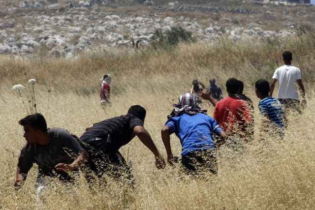 Mladí Palestinci házejí kameny na skupinku židovských osadníků u Nábulusu na západním břehu Jordánu. | Foto: Reuters