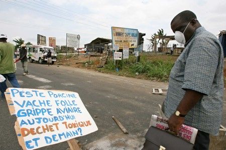 Obyvatel Abidžanu si prohlíží ceduli s nápisem "Prasečí mor, nemoc šílených krav, ptačí chřipka dnes toxický odpad. A zítra?" Během protestů v největším přístavu na Pobřeží Slonoviny | Foto: Reuters