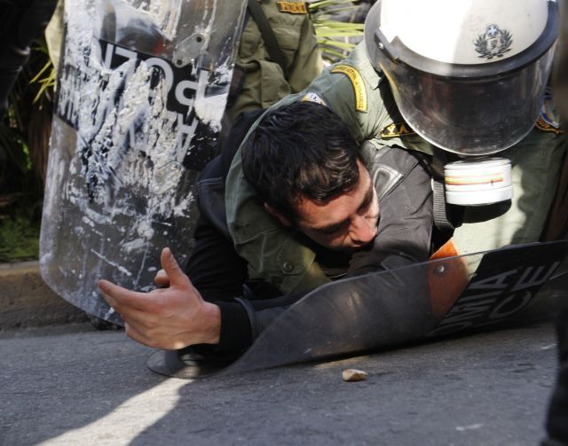 Policista a demonstrant se perou na aténské dlažbě. Něpokoje v řeckých městech zuří už druhým týdnem. | Foto: Reuters