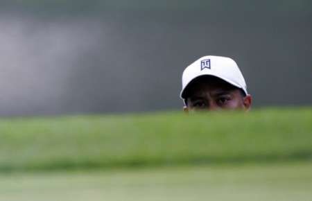 Tiger Woods sleduje svůj odpal při tréninku na 88. PGA Championship v Medinah. | Foto: Reuters