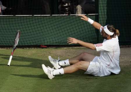 Kyperský tenista Marcos Baghdatis odhazuje svoji raketu při semifinále Wimbledonu proti se Španělem Rafaelem Nadalem. | Foto: Reuters