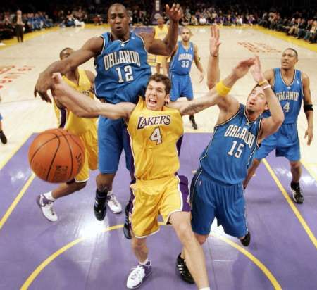 Luke Walton z Los Angeles Lakers (uprostřed) bojuje o doskok s Dwightem Howardem (vlevo) a Hedo Turkoglem (vpravo) z Orlanda Magic v zápase basketbalové NBA. | Foto: Reuters