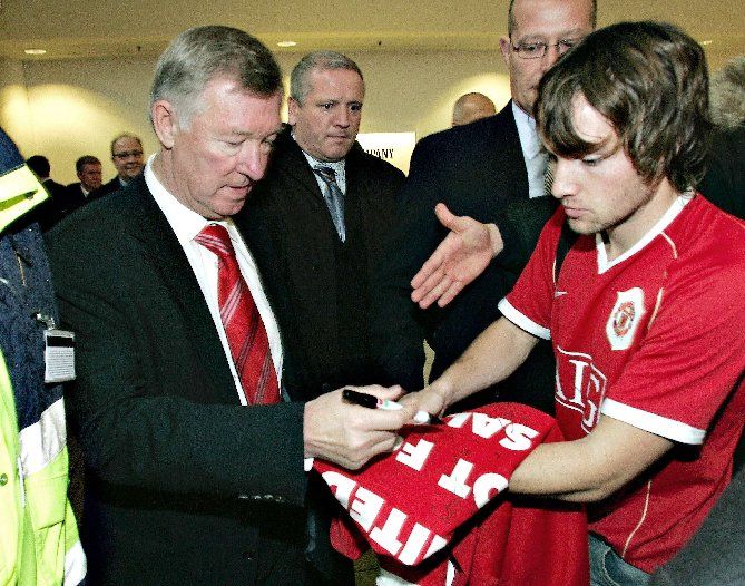 Alex Ferguson je uznávaná celebrita. Po příletu s Manchesterem United do Kodaně se podepisuje fanouškovi na dres. | Foto: Reuters