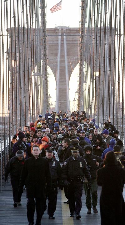 Lidé, kteří kvůli stávce nemohli použít metro, autobusy ani vlaky, jdou po brooklynském mostu společně s newyorským starostou Michaelem Bloombergem. | Foto: Reuters/Seth Wenig