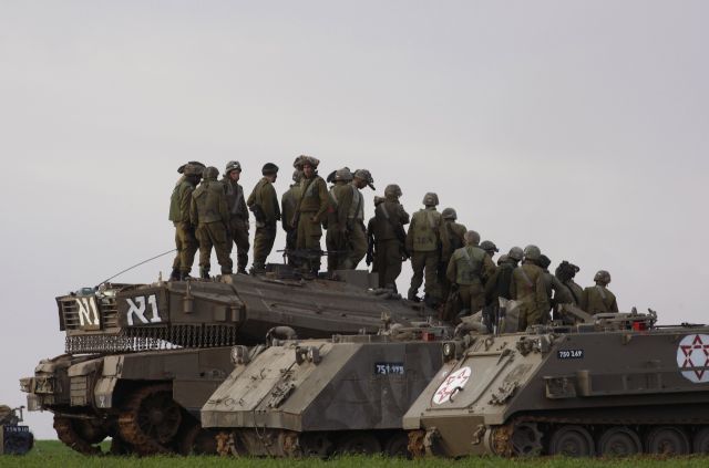 Izraelští vojáci postávají na tancích u hranice s pásmem Gazy. | Foto: Reuters