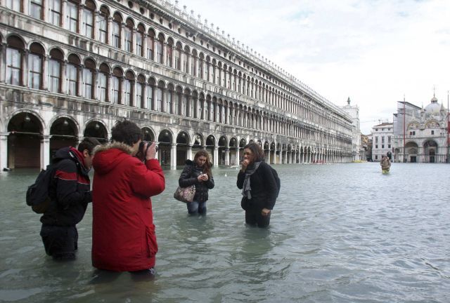 Někteří turisté si dnešní benátskou záplavu užívají. | Foto: Reuters