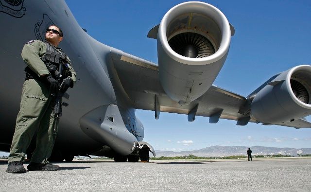 Americký voják hlídá nákladní letadlo v Port-au-Prince. | Foto: Reuters