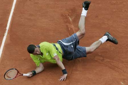 Ruský tenista se marně snaží proti Janku Tipsarevičovi. Letos vypadl s French Open už v prvním kole. | Foto: Reuters