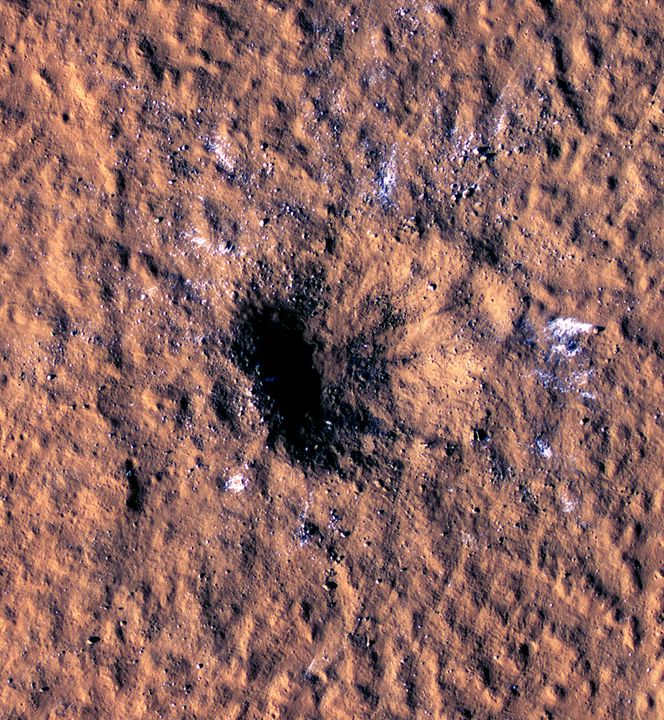 Na Vánoce minulého roku dopadl na Mars meteorit, který mohl mít v průměru až dvanáct metrů. Fotografie zachycuje kráter, který letící objekt vytvořil a jenž odhalil led pod povrchem. Ten by mohl být v budoucnu přeměněn na vodu, NASA proto zvažuje, že na místo vyšle astronauty. | Foto: Reuters