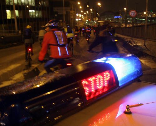 Cyklisté na chvíli zastavili dopravu na pražské magistrále. Na cestě z Vinohrad na místo neštěstí je doprovázelo policejní auto. | Foto: Ondřej Besperát, Aktuálně.cz