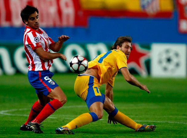 Jose Manuel Jurado (Atletico) v souboji s Kamilem Kosowskim (APOEL Nicosia). | Foto: Reuters