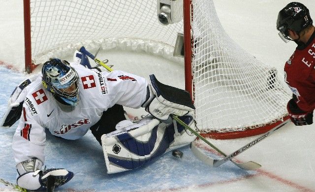 Švýcarský brankář Jonas Hiller likviduje jednu ze šancí Kanaďana Erica Staala ve čtvrtfinále světového šampionátu. | Foto: Reuters