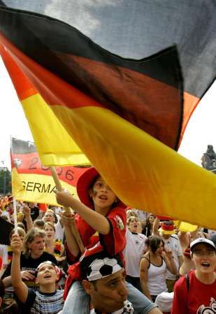 Německá fanynka mává vlajkou v ulicích Stuttgartu před zápasem o bronz s Portugalskem. | Foto: Reuters