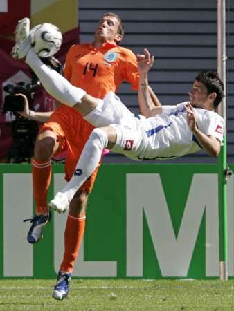 Útočník Srbska a Černé Hory Mateja Kežman se snaží zakončit nůžkami, brání ho John Heitinga (vlevo). | Foto: Reuters