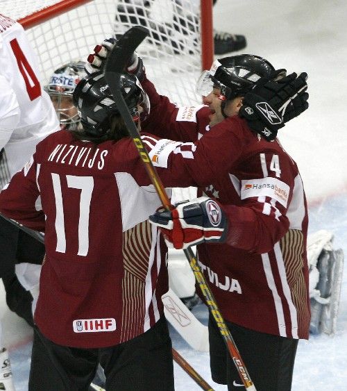 Hokejisté Lotyšska Aleksandrs Niživijs (vlevo) a Leonids Tambijevs slaví gól do rakouské branky v zápase o udržení v elitní skupině MS. | Foto: Reuters