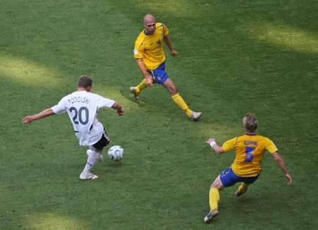 Německý útočník Lukas Podolski (v bílém) se napřahuje k prvnímu gólu ve švédské síti. | Foto: Reuters