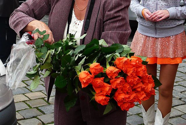 Vezmete si růžičku? Místostarosta Prostějova se směje na potencionální voličky a při předávání květiny koketně prolomí kolena. Maminky s kočárky ani důchodkyně oranžové symboly za romantického zpěvu Petry Janů neodmítnou, mnohé si dokonce říkají o víc než jeden květ. Růže se nakonec dostanou i na muže, strana jich přinesla na mítink stovky. | Foto: Ondřej Netočný