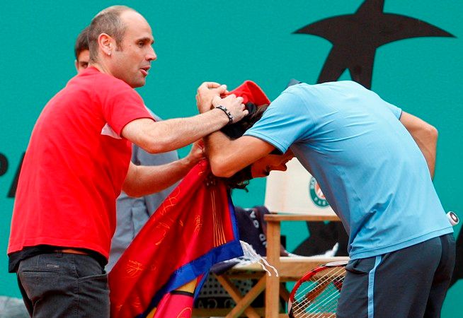 Jeden z diváků vběhl při finále Roland Garros na kurt. A ochranka měla plné ruce práce. | Foto: Václav Rojík