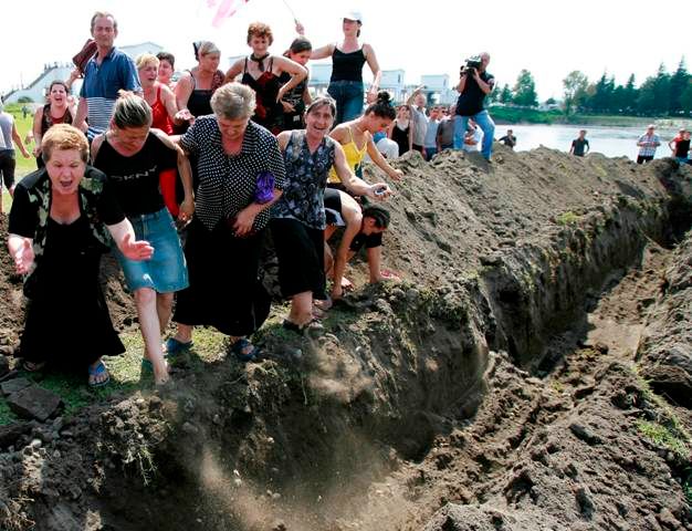 Gruzínky křičí na ruské vojáky, kteří u města Poti vytvářejí své stanoviště a hloubí příkop. Demonstranti se snaží příkop opět zahrabat | Foto: Reuters