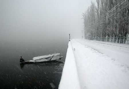 Zatímco my jsme si letošní zimu stěžovali na nedostatek sněhu, v kašmírském Šrinagaru mají lidé problém opačný. Rybáře zastihlo březnové sněžení při prácí na jezeře Dal Lake . | Foto: Reuters