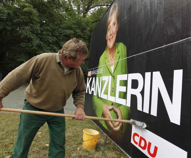 Předvolební kampaň znamená pro lepiče plakátů hodně práce. | Foto: Reuters