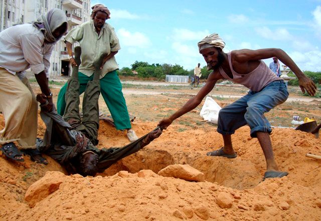 Obyvatelé Mogadiša pohřbívají mrtvého bojovníka loajálního vládě | Foto: Reuters