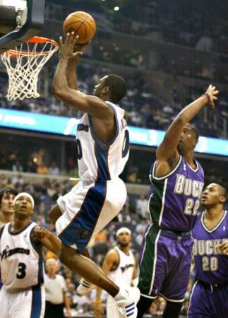 Gilbert Arenas z Washingtonu Wizards se prodírá přes Michaela Redda a Jamaa z Milwaukee Bucks. | Foto: Reuters