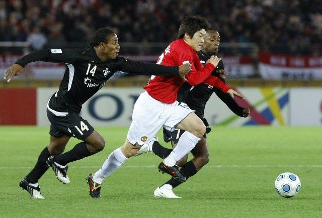 Park Ji-Sung z Manchesteru United se snaží probít přes Diega Calderona (vlevo) a Luise Bolanose z LDU Quito ve finále MS klubů. | Foto: Reuters