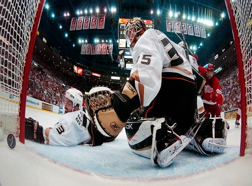 Francois Beauchemin z Anaheimu (vlevo) se marně snaží dohnatpuk, který zamířil za záda Jeana-Sebastiena Giguera v zápase s Detroitem. | Foto: Reuters