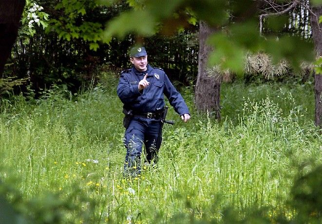 Policista prohledává okolí domu, kde se měl údajně skrývat Ratko Mladič. (Archivní snímek z 5.5.2006) | Foto: Reuters