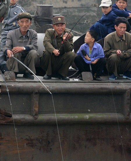 Rybáři ve městě Sinujiu na severokorejské straně řeky Ja-lu, která odděluje Severní Koreu od Číny. | Foto: REUTERS / Reinhard Krause