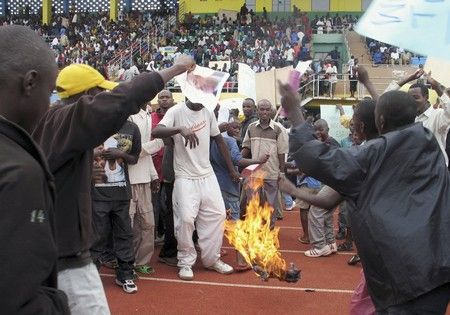 Rwandští demonstranti pálí francouzskou vlajku při protestu proti požadavku Francie postavit prezidenta Paula Kagameho před soud za účast na genocidě. | Foto: Reuters