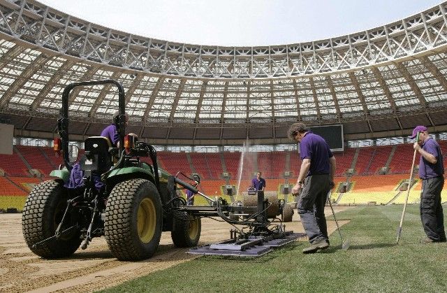 Dělníci pokládají v moskevských Lužnikách nový trávník. Patnáct dní před finále LM. | Foto: Reuters