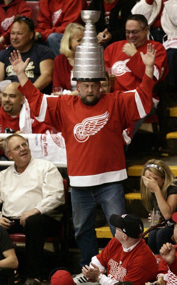 Detroitský fanoušek tančí v hledišti s napodobeninou Stanley Cupu na hlavě. | Foto: Reuters