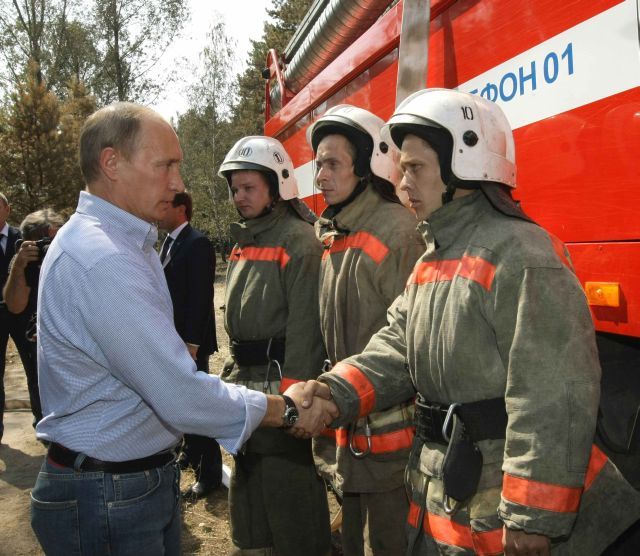 Vladimir Putin se zdraví s hasiči u Voroněže. | Foto: Reuters