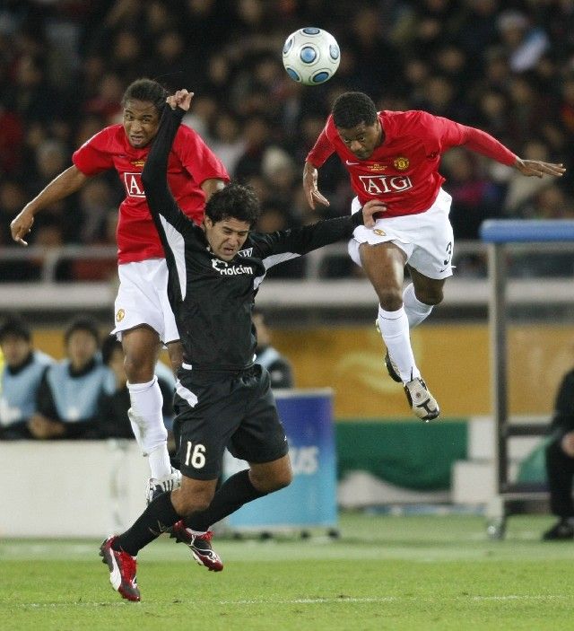 Claudio Bieler z ekvádorského LDU Quito v obklíčení manchesterského Patrice Evry (vpravo) a Andersona. | Foto: Reuters