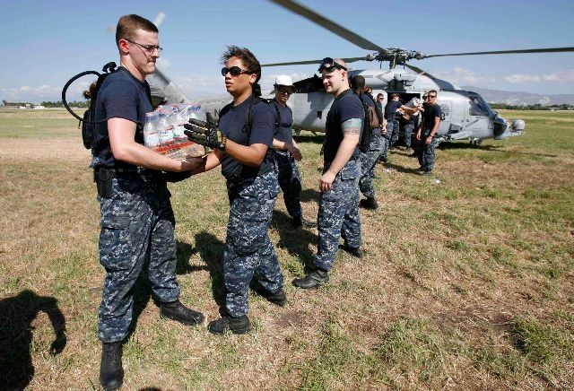 Američané nakládají do helikoptéry balíky vody. | Foto: Reuters