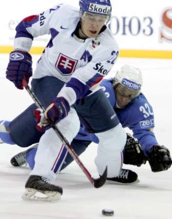 Slovenský hokejista Richard Kapuš(vlevo) v souboji s Kazachstáncem Nikolajem Zarzhitskim. | Foto: Reuters